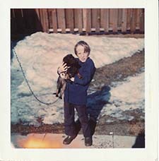 Kevin Pelletier as a small boy with a cute dog in his arms on a snowy day.
